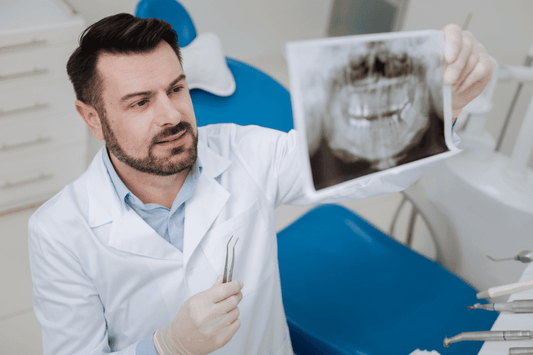 orthodontist holding up xrays of teeth in office holding tool