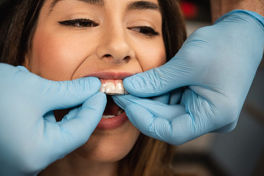 orthodontist placing clear aligners on teeth